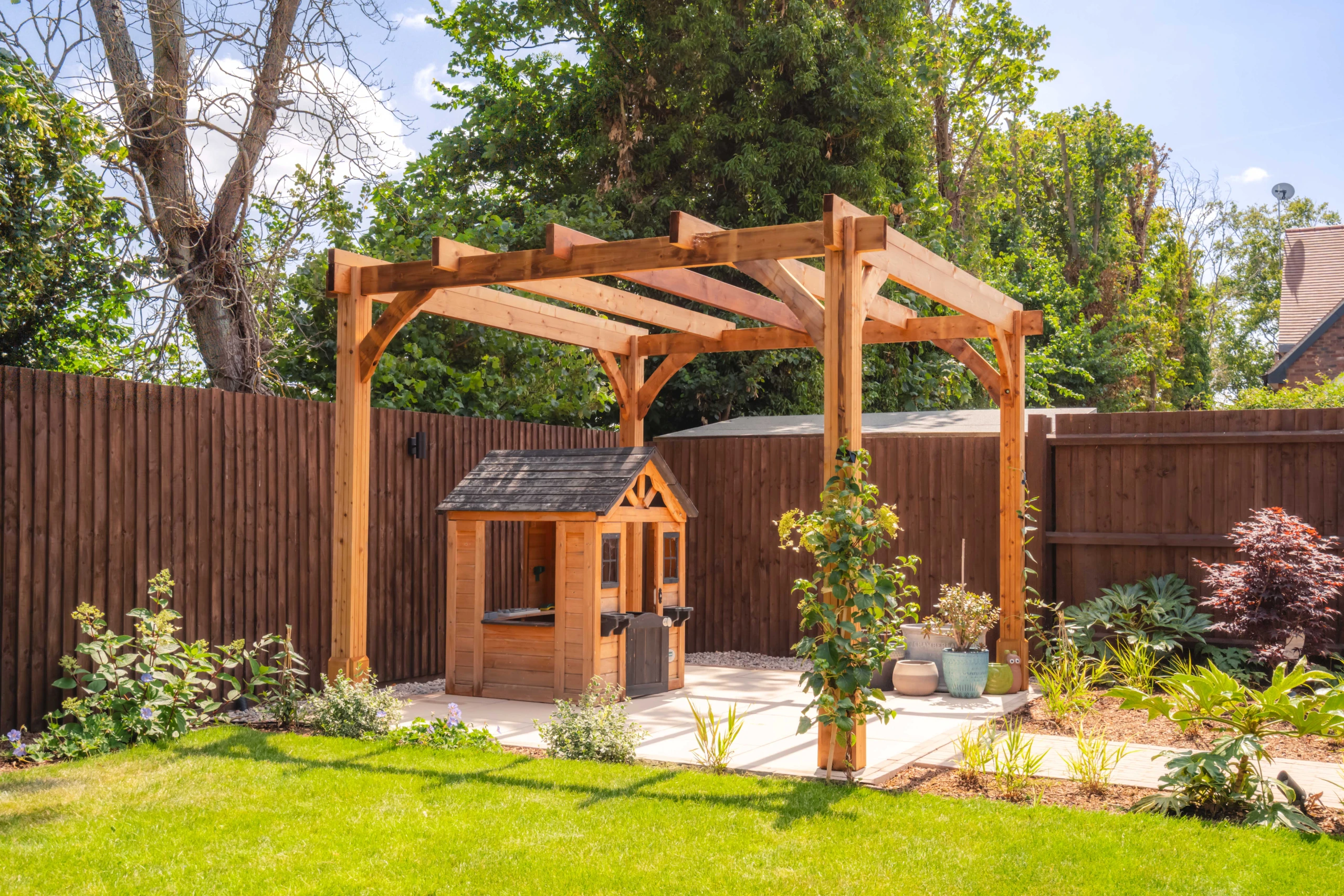 Image shows a pergola and playhouse in a garden