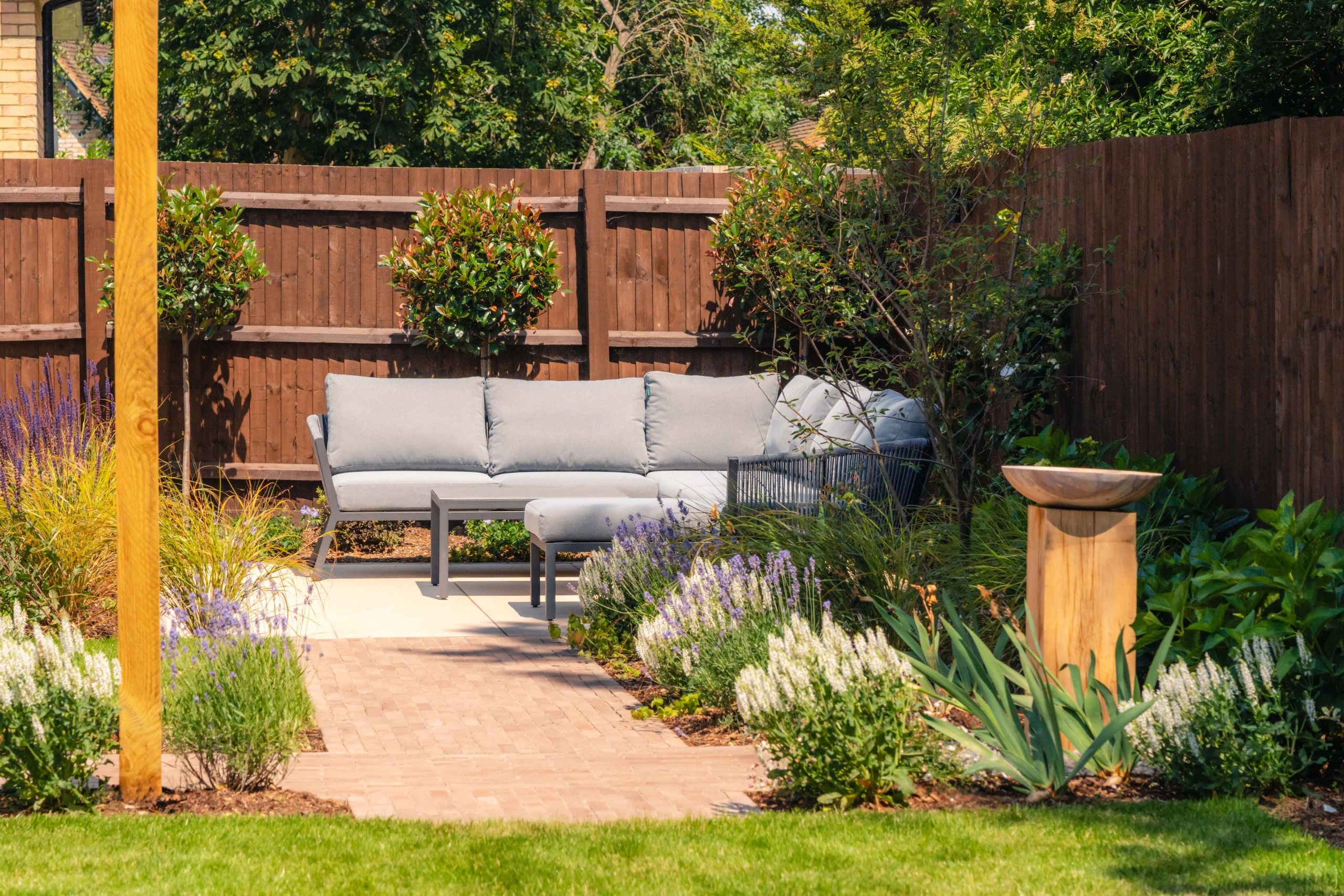 Image shows an outdoor seating area with garden sofa